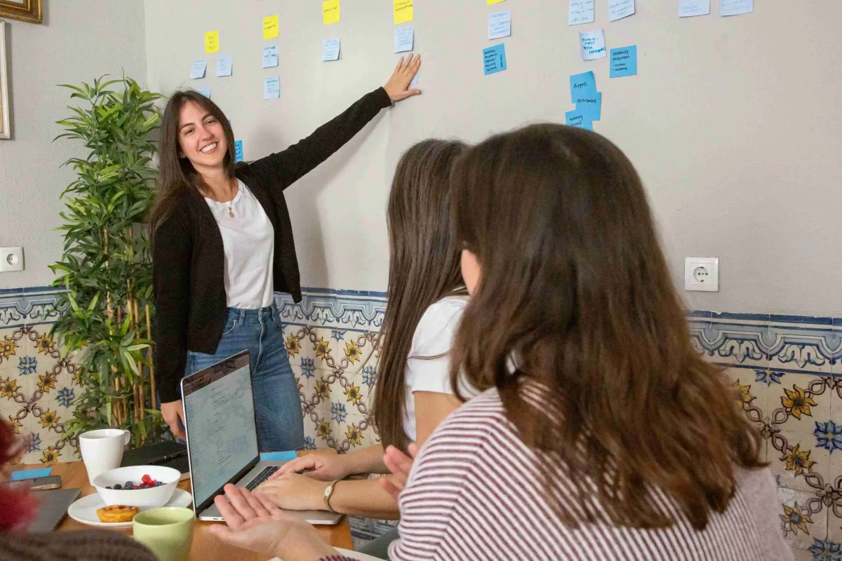 A team member presenting ideas on sticky notes during a workplace planning session