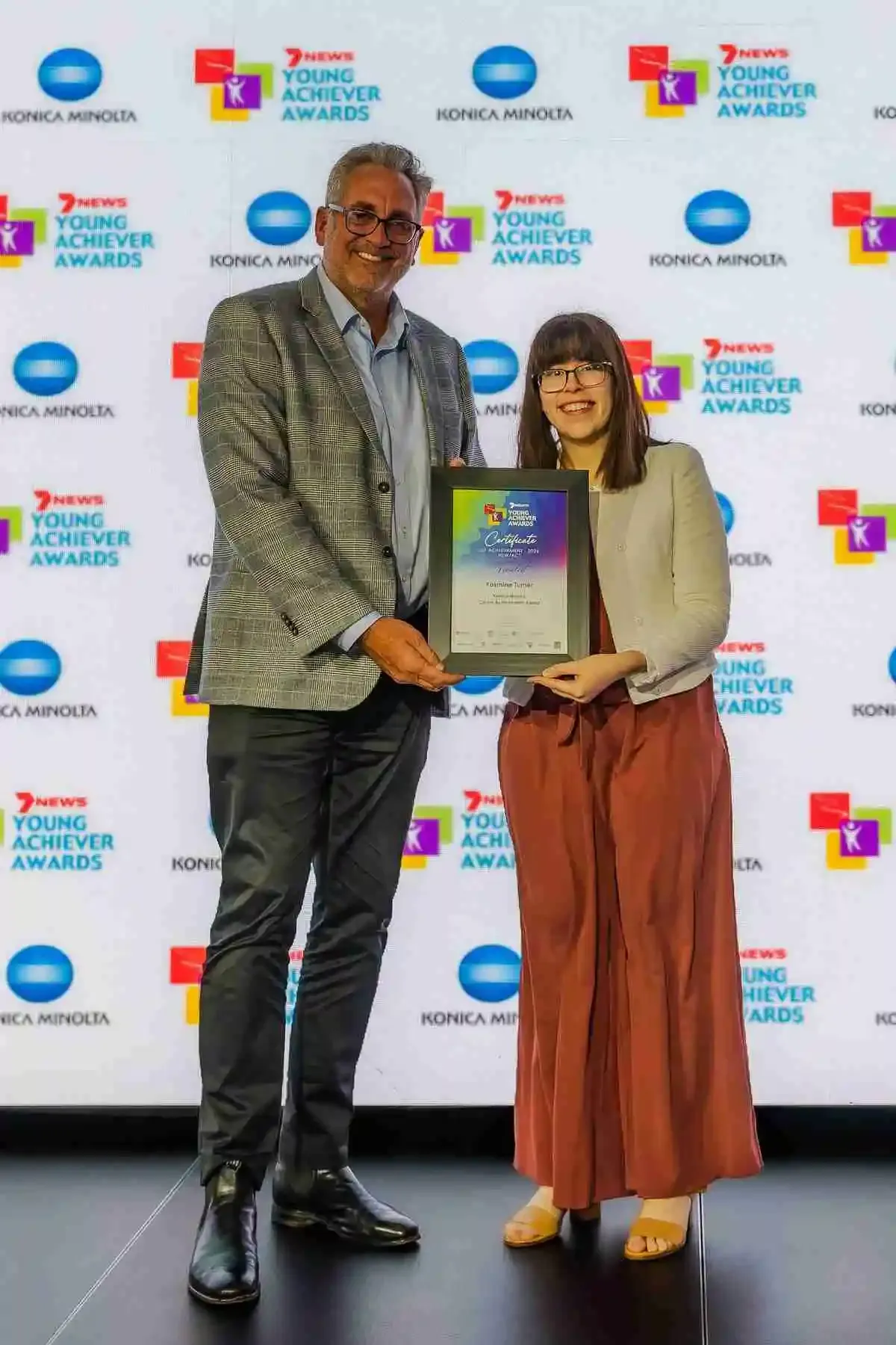 Yasmine Turner being presented with her 2026 7NEWS Young Achiever Awards finalist certificate on stage